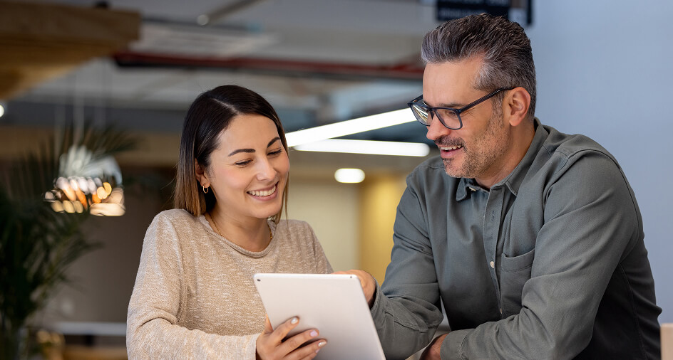 Photo of a man and women looking at a tablet device